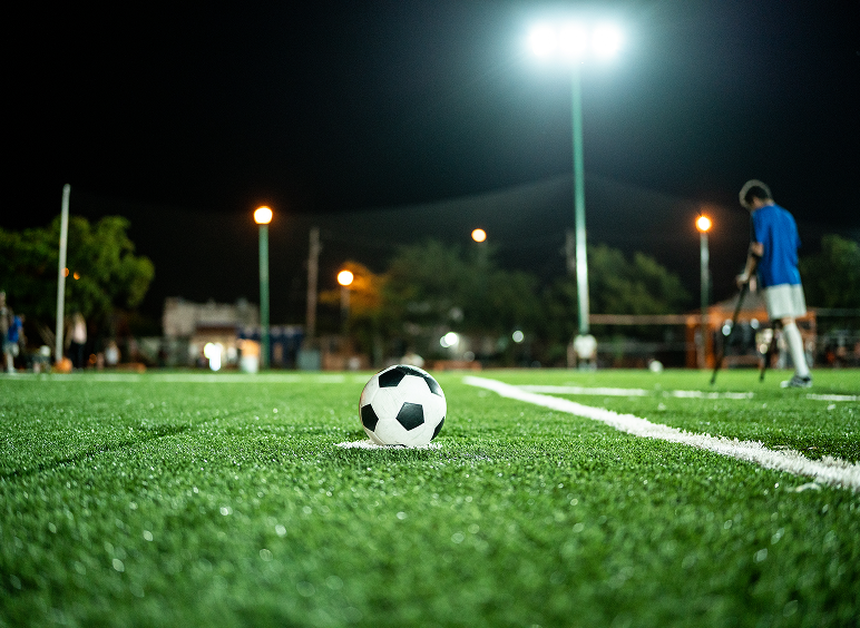 Soccer ball on field at night game.