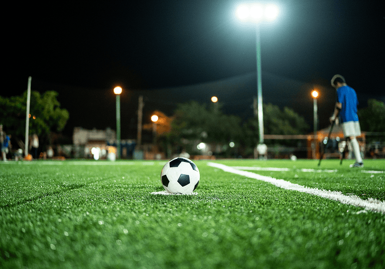 Soccer ball on field at night game.